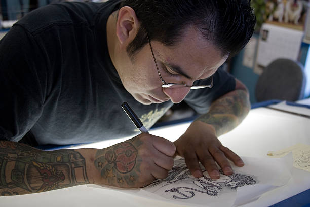 photo of tattoo artist drawing up a stencil