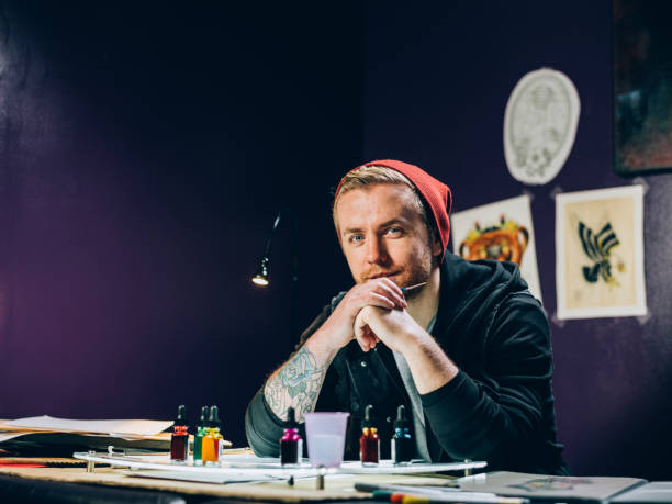 photo of tattoo artist sitting at a table