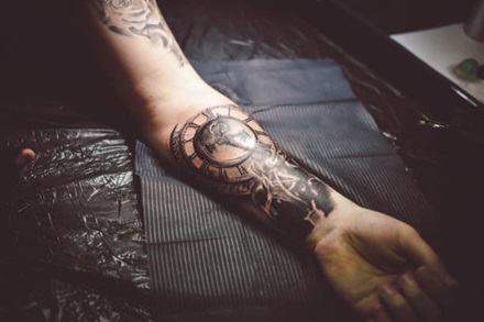photo of forearm black and grey clock tattoo
