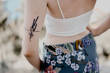 fine line tattoo of flowers on back of an upper arm