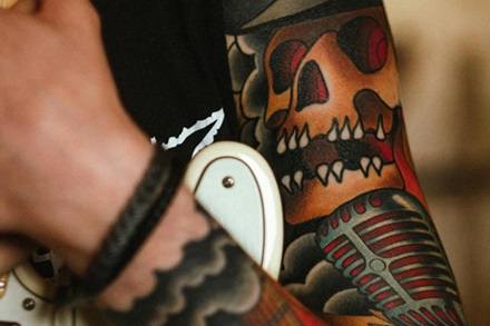 traditional sleeve tattoo of skeleton musician